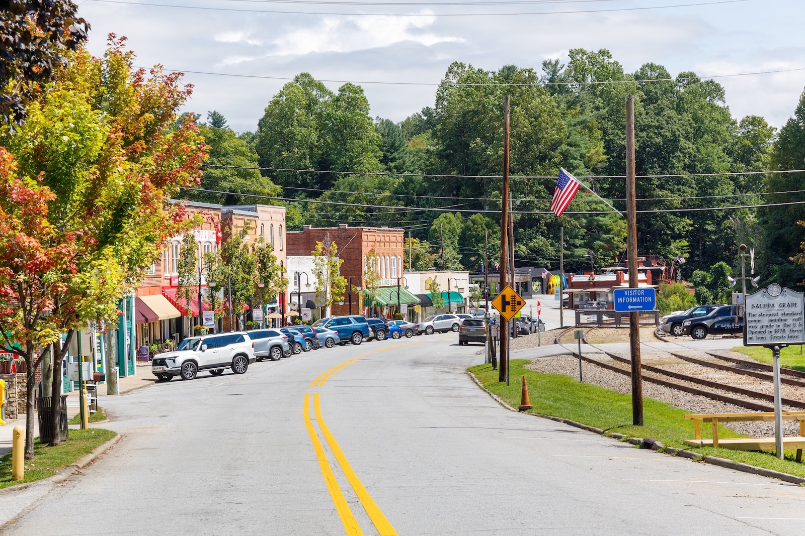 Downtown Saluda, NC, with town buildings, a road, a railroad and the Saluda Grade sign.