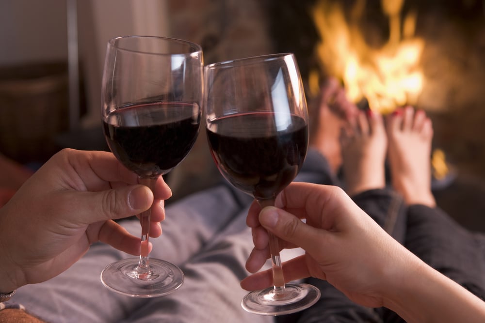 Couple enjoying wine by the fire during their North Carolina getaways