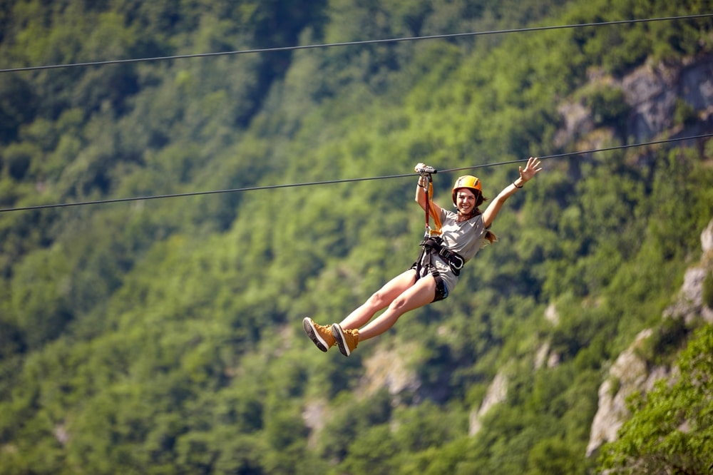 Woman riding a zipline like The Gorge Zipline in Saluda