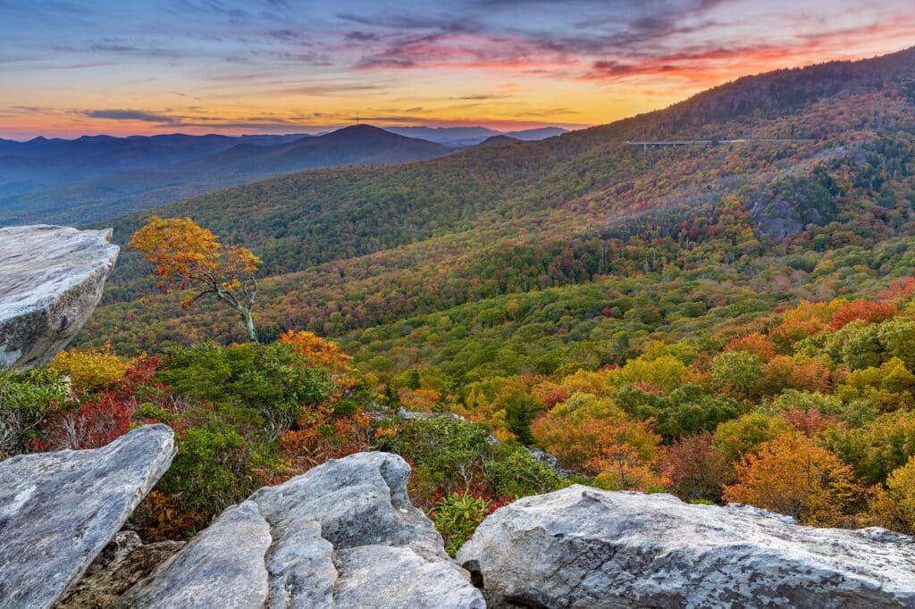 Your Guide to Fall Colors in North Carolina 1 Sunset over the Rough Ridge Overlook and Trail on Blue Ridge Parkway, showcasing fall colors in North Carolina on the mountains.