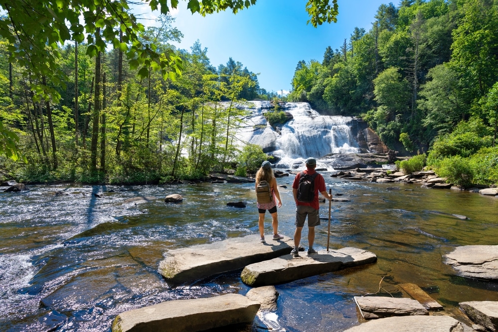 Couple hiking to a waterfall, one of the best things to do in Western North Carolina