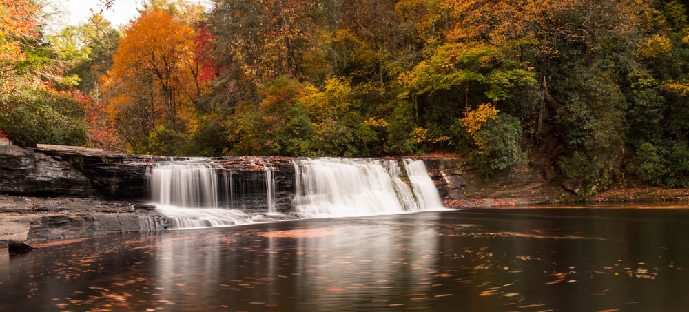 Beautiful foliage around a waterfall - this is why fall is the best time to visit North Carolina