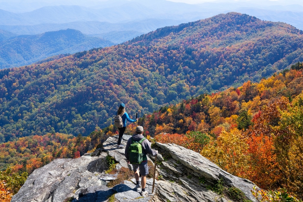 Your Guide to Western North Carolina Fall Foliage 4 Couple hiking through some of the best Western North Carolina fall foliage