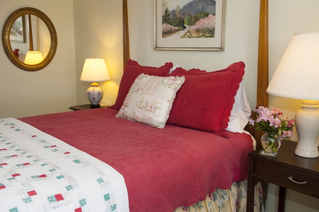 The Orchard Inn & Spa, one of the best Mountain getaways NC. Enjoy this four poster queen sized bed in one of many luxurious rooms.