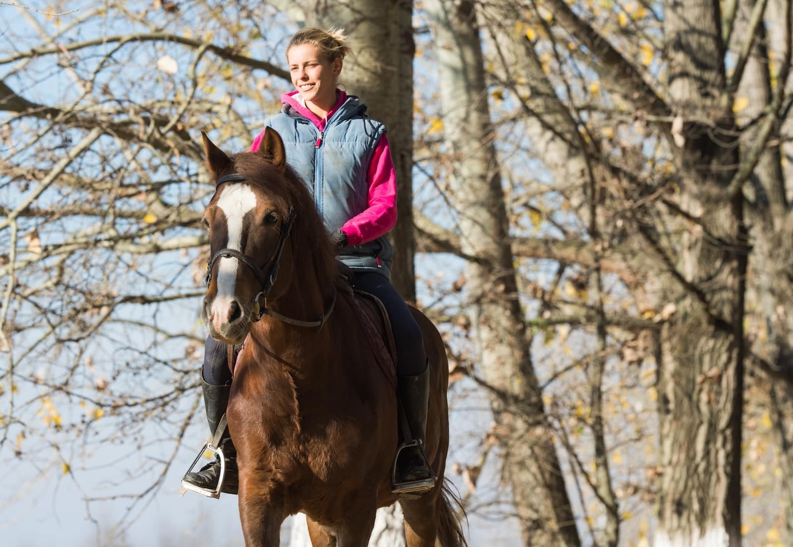 Enjoy horseback riding near Asheville! A young woan horseback riding. 