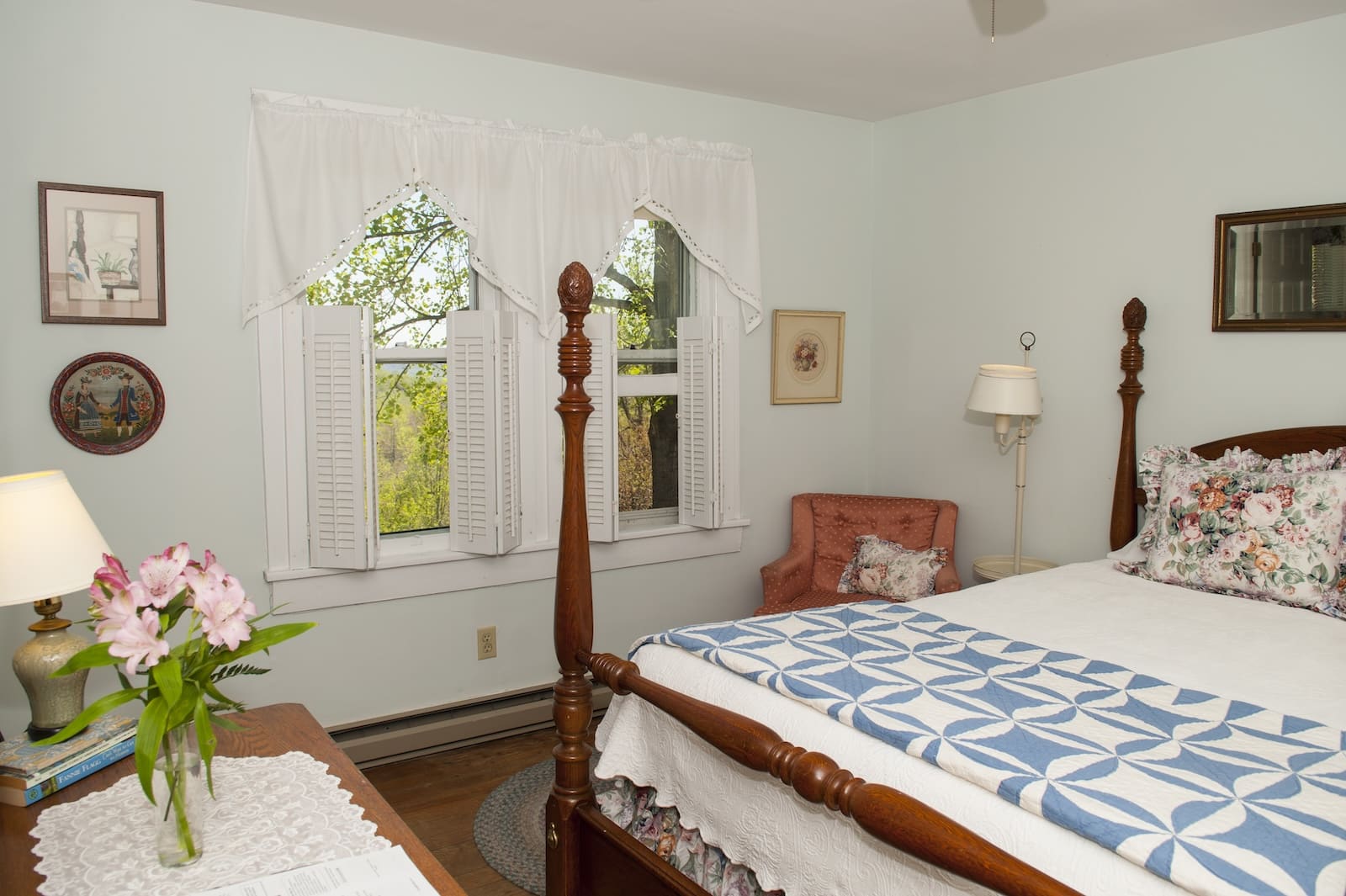A room with a chair and a dresser and mountain views out the window at a bed and breakfast in Saluda NC.